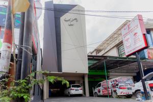 un edificio con coches estacionados frente a él en Urbanview Hotel Priority Samarinda by RedDoorz en Samarinda