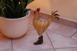 Una decoración de pavo real de madera junto a una planta. en 4 Sterne Apartment Kap Arkona mit Balkon, en Lobbe 2 fotos más