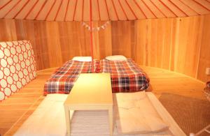 糸島市にあるGlamping nijo in Itoshima - Vacation STAY 71943vのベッドとテーブル付きの小さな部屋