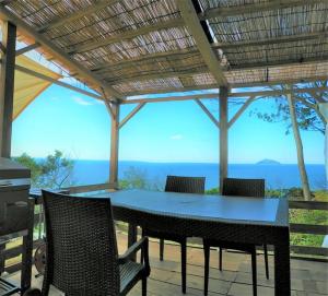 una mesa y sillas en un patio con vistas al océano en Glamping nijo in Itoshima - Vacation STAY 71943v, en Itoshima