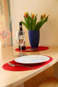 a table with a plate and a vase with flowers at 4 Sterne Apartment Hühnergott mit Terrasse und Sauna in Lobbe