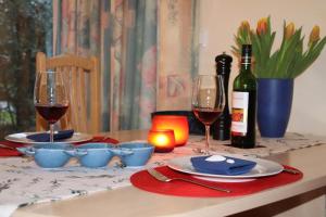 a table with two wine glasses and a bottle of wine at 4 Sterne Apartment Kormoran mit Terrasse und Sauna in Lobbe