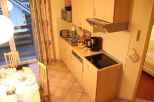 Una pequeña cocina con un fregadero y una mesa. en 4 Sterne Apartment Seeadler mit Balkon, en Lobbe