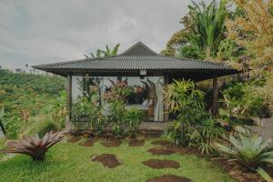 a gazebo with people in it in a garden at Kayukopi in Munduk