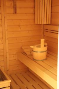 una sauna de madera con un cubo en un estante en 4 Sterne Apartment Ruden mit Sauna und Terrasse, en Lobbe 2 fotos más