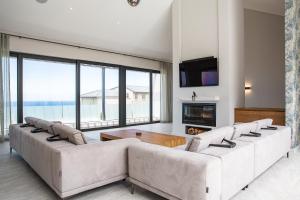 a living room with two white couches and a fireplace at Miles End Pezula in Knysna