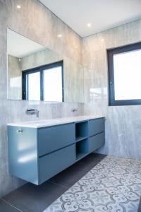 a bathroom with a blue sink and a mirror at Miles End Pezula in Knysna