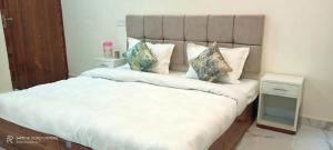 Un dormitorio con una cama grande con sábanas y almohadas blancas. en Dream palace home stay, en Khajurāho