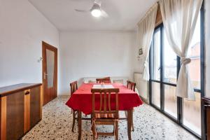 uma sala de jantar com uma mesa vermelha e cadeiras em Easy Old City Apt Venice em Marghera