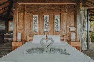 Dos cisnes forman un corazón en una cama en Kayukopi en Munduk