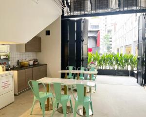 a kitchen with a table and green chairs at Code Hostel Singapore in Singapore