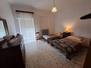 a bedroom with two beds and a desk and a window at CASA VACANZE L'OLIVO in Lubriano