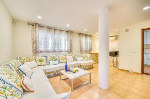 a living room with a white couch and a table at Casa Maylin in Can Picafort