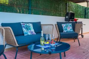 a patio with a blue couch and chairs and a table at Casa Maylin in Can Picafort