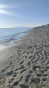 a beach with footprints in the sand and the water at Chalet Chilches Costa 1ª linea PLAYA in Vélez-Málaga