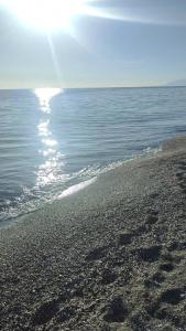 una playa con el sol reflejándose en el agua en Chalet Chilches Costa 1ª linea PLAYA, en Vélez-Málaga