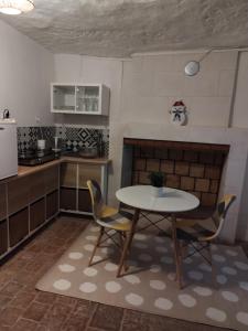Le Grand-PressignyにあるPetite maison troglodyteのキッチン(テーブル、椅子付)