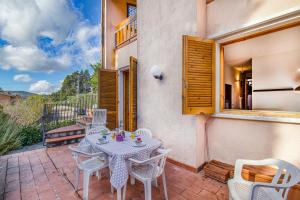 patio con mesa, sillas y ventana en Casa Acone In Mugello - Happy Rentals, en Scopeti