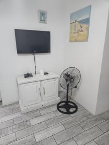 een kamer met een ventilator en een televisie aan de muur bij Sea Scapes Holiday Apartment in Margate