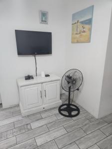 a room with a fan and a television on a wall at Sea Scapes Holiday Apartment in Margate