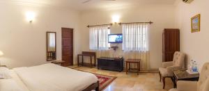 una camera con letto, TV e sedia di Kishen Villa a Jodhpur