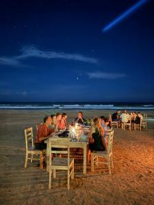 a group of people sitting at a table on the beach at Esperanza Beach Mawella in Tangalle