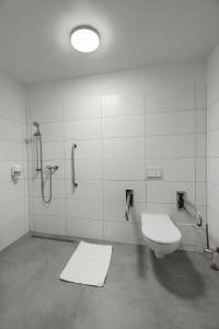 a bathroom with a toilet and a shower at Płonia Resort in Szczecin