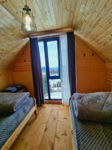 a room with two beds and a large window at Cottage SuBree on Goderdzi in Goderdzi