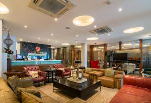 una gran sala de estar con sofás y un bar. en Baboona Beachfront Living, en Pattaya central