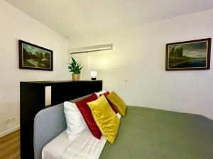 a room with a bed with colorful pillows on it at Luxury Suites Mons by Rikas Hotels in Mons