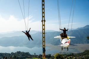 two people are jumping from a zip line on a helicopter at Naya Gaun Eco Resort in Pokhara