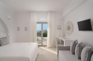 a white bedroom with a bed and a couch at White Dunes Luxury Boutique Hotel in Santa Maria