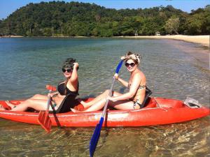 two women are sitting in a kayak in the water at Room in Bungalow - Breathtaking Cottage of Koh Pu in Ko Jum