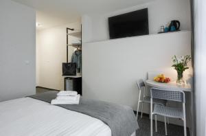 a bedroom with a bed and a table with a tv at Płonia Resort in Szczecin
