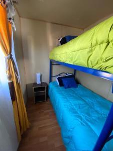 a bedroom with a bunk bed with a blue bedsheet at Cabaña Maite in Panguipulli
