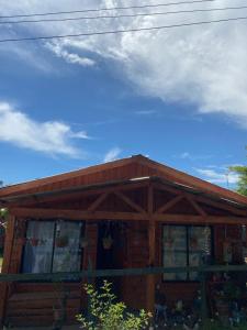 Cabaña de madera con techo y cielo nublado en Cabaña Maite en Panguipulli