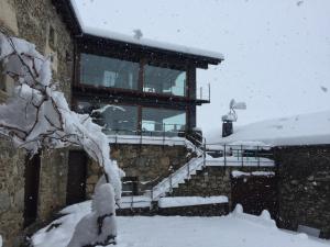 a building covered in snow with snow covered stairs at Mas Farner - Adults Only in Llivia