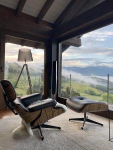 een woonkamer met 2 stoelen en een groot raam bij Mas Farner - Adults Only in Llivia