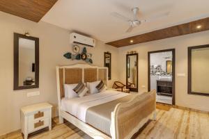 a bedroom with a large bed and two mirrors at Le dando Beach Resort by Orion Hotels in Old Goa