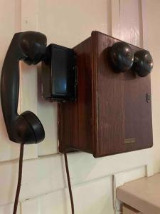 un téléphone fixé à un mur avec un téléphone dans l'établissement The Groves at Redway Beach - Craftsman, à Redway