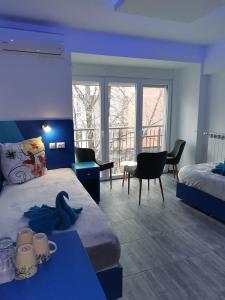 een slaapkamer met een blauwe kamer met een bed en een bureau bij Бутик хотел ресторант брасери Сажитариус in Kyustendil