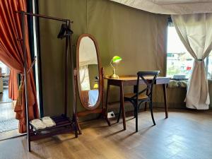 Cette chambre comprend une table avec un miroir et une chaise. dans l'établissement kMah@SomerMansion, à Tanah Rata