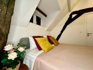a bedroom with a bed with yellow and red pillows at Luxury Suites Mons by Rikas Hotels in Mons