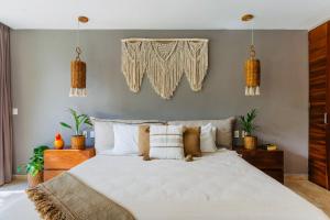 a bedroom with a large white bed with pillows at Luz de Luna Tulum Suite II in Tulum