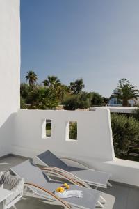 a white building with tables and chairs on a balcony at White Dunes Luxury Boutique Hotel in Santa Maria
