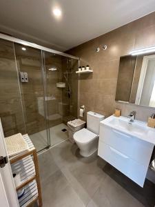 een badkamer met een douche, een toilet en een wastafel bij Apartamento Benicàssim Sunset Calm&Views in Benicàssim