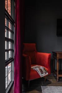 a red couch in a room with a window at The Chum Boutique in Hue