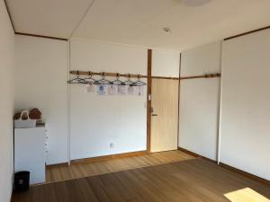 an empty room with white walls and wooden floors at もりぞう in Tomioka