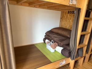 a bunk bed in a tiny house with shoes on the floor at もりぞう in Tomioka