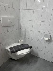 un bagno bianco con un asciugamano nero su un WC di The Steakhouse - Guest Rooms a Sankt Johann im Pongau